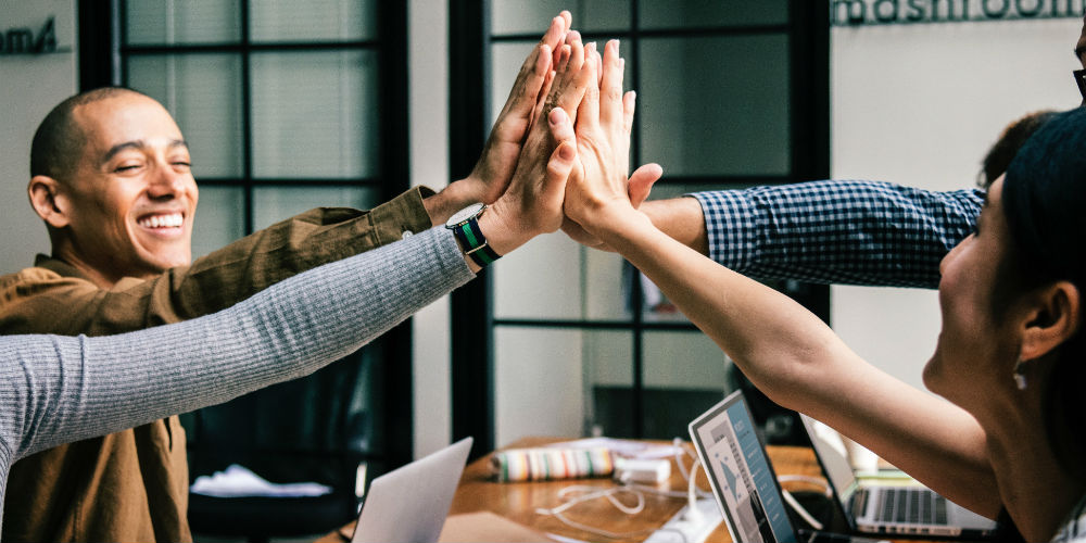 Employees high-fiving at work