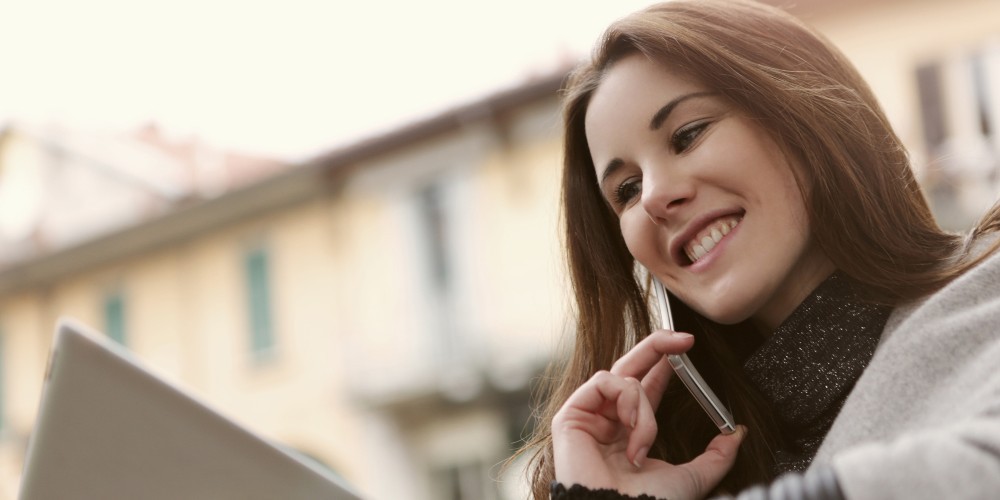 woman on phone and laptop